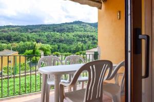 una mesa blanca y sillas en un balcón con vistas en Can Falga Alojamiento en el corazón de Besalú, en Besalú