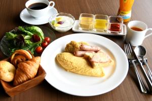 una mesa con un plato de comida con salchichas y pan en Hotel Marroad Hakone, en Hakone