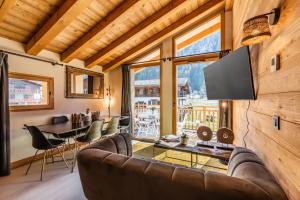 una sala de estar con un sofá y una mesa en Sapelli apartment Argentière Chamonix - by EMERALD STAY, en Chamonix-Mont-Blanc