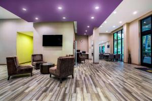 a waiting room with chairs and a flat screen tv at La Quinta by Wyndham Pomona in Pomona