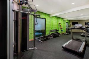 a gym with a green brick wall and a treadmill at La Quinta by Wyndham Pomona in Pomona