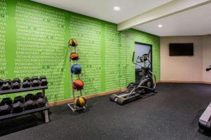 a gym with a green wall with balls on it at La Quinta by Wyndham Pomona in Pomona