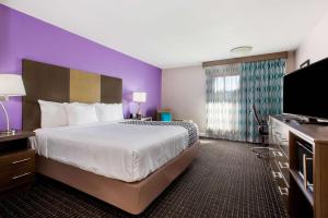 um quarto de hotel com uma cama grande e uma televisão de ecrã plano em La Quinta by Wyndham Pomona em Pomona