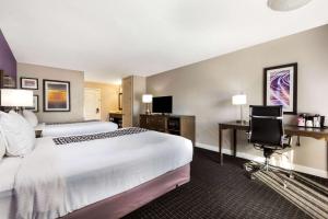 a hotel room with a large bed and a desk at La Quinta by Wyndham Pomona in Pomona
