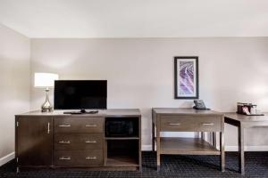 a hotel room with a desk and a flat screen tv at La Quinta by Wyndham Pomona in Pomona