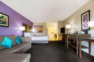 a hotel room with a bed and a couch at La Quinta by Wyndham Pomona in Pomona