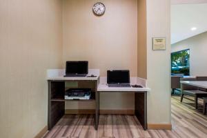 an office with two computers on a desk with a clock at La Quinta by Wyndham Pomona in Pomona