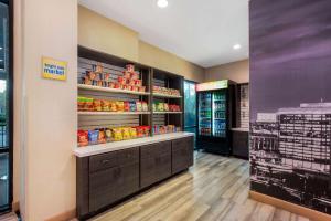 a grocery store aisle with a refrigerator and shelves of food at La Quinta by Wyndham Pomona in Pomona