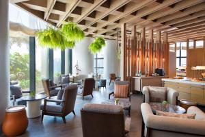 um átrio com cadeiras, mesas e janelas em Andaz Singapore A Concept by Hyatt em Singapura