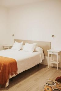 a bedroom with a white bed and a table at Apartamento de la Candelaria I in Santa Cruz de Tenerife