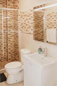 een witte badkamer met een toilet en een wastafel bij Apartamento de la Candelaria I in Santa Cruz de Tenerife