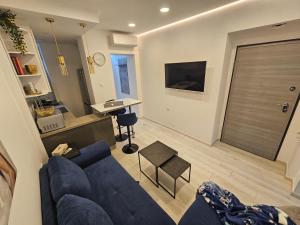 Una sala de estar con un sofá azul y una cocina. en Apartment Oliver, en Rijeka