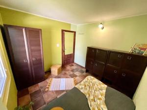 a room with green walls and brown cabinets and a mirror at Hotelik nad Jeziorem in Łasin
