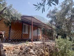 a house with a fence in front of it at Karavan Kır Evi in Mugla