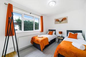 a bedroom with two beds and a window at 3-bedroom, sleeps 5 with discounts on long bookings in Loughton