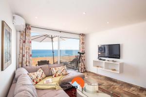 salon z kanapą i widokiem na ocean w obiekcie #017 Private SeaView with AC, 200 mts Beach w Albufeirze