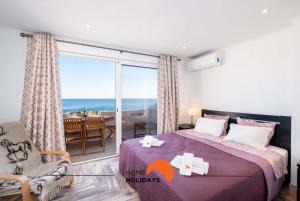 sypialnia z łóżkiem i widokiem na ocean w obiekcie #017 Private SeaView with AC, 200 mts Beach w Albufeirze