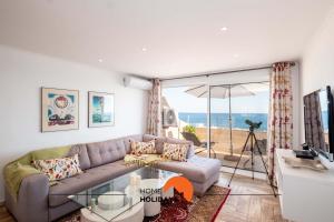 uma sala de estar com um sofá e uma mesa de vidro em #017 Private SeaView with AC, 200 mts Beach em Albufeira