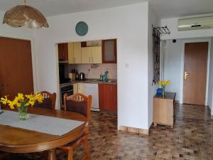 cocina y comedor con mesa y sillas en Apartmani Doroteja en Bibinje