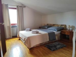 1 dormitorio con 1 cama con 2 toallas en Apartmani Doroteja, en Bibinje