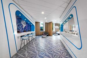 a lobby with a bar with blue and white tiles at prizeotel Hamburg-St.Pauli in Hamburg