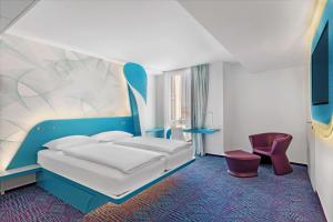 ein Hotelzimmer mit einem Bett und einem Stuhl in der Unterkunft prizeotel Hamburg-St.Pauli in Hamburg