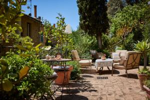 un patio con sedie e tavoli in giardino di Residenza Stuart - Green Tea - Dimora Storica a Montepulciano
