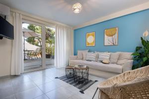 un soggiorno con divano e tavolo di Vouliagmeni Stylish Homes by BluPine ad Atene