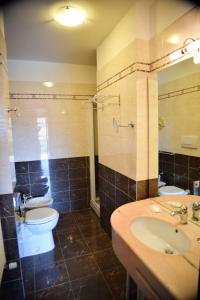 ein Badezimmer mit einem Waschbecken, einem WC und einem Spiegel in der Unterkunft Panorama Hotel in Muggia