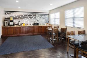a restaurant with a bar and tables and chairs at Super 8 by Wyndham Lindenhurst 