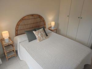 - une chambre avec un grand lit blanc et deux lampes dans l'établissement Apartamentos Fuentesol Altamar, à Alcossebre