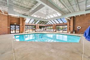 Una gran piscina en un edificio con techo de cristal. en SureStay Plus Hotel by Best Western Price, en Price