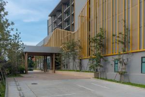 an external view of a building with a yellow facade at Best Western Plus Carapace Hotel Hua Hin in Hua Hin