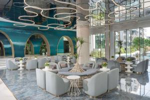 a lobby with white chairs and tables and a blue wall at Best Western Plus Carapace Hotel Hua Hin in Hua Hin