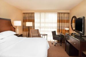 a hotel room with a large bed and a television at Courtland Grand Hotel, Trademark Collection by Wyndham in Atlanta