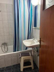 a bathroom with a sink and a shower curtain at Agni in Nafpaktos