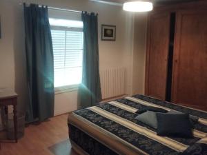 um quarto com uma cama grande e uma janela em Au Sourire des Jeunes em Brécey