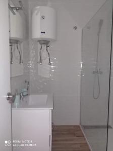 a white bathroom with a sink and a shower at Raquel Apartament in Alicante