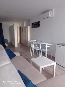 a living room with a couch and a table and chairs at Raquel Apartament in Alicante