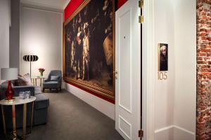 a living room with a large painting on the wall at Tivoli Doelen Amsterdam Hotel in Amsterdam