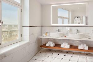 ein Badezimmer mit 2 Waschbecken und einem Spiegel in der Unterkunft Tivoli Doelen Amsterdam Hotel in Amsterdam