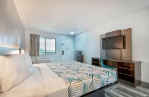 a hotel room with a bed and a television at Motel 6 Texarkana, TX in Texarkana