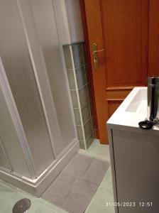 baño con ducha y puerta de cristal en AR Villa Rica Apartment en Santa Comba