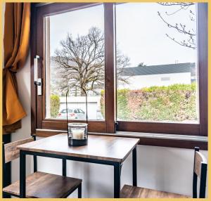 einen Tisch und zwei Stühle vor einem Fenster in der Unterkunft Studio Haut de gamme Cluses in Cluses
