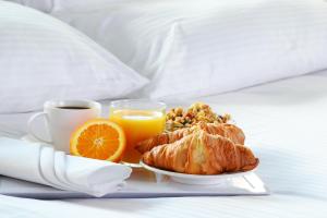 un plato de desayuno con cruasanes y naranjas y una taza de café en Residence Inn Joplin, en Joplin