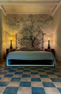 1 dormitorio con 1 cama con una pintura en la pared en Podere L'Olmaia, en Marsiliana