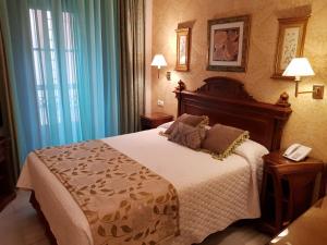 a hotel room with a bed with a phone on it at Hotel Europa Boutique Sevilla in Seville