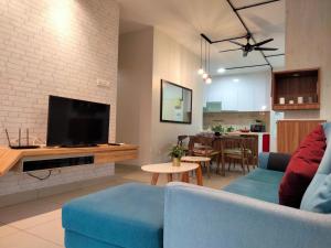 a living room with a blue couch and a tv at OUG Signature 3Br 6pax Old Klang Road in Kuala Lumpur