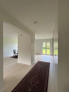 Habitación blanca grande con alfombra y mesa en Villa nära till natur och stan, en Gotemburgo