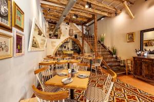 a restaurant with wooden tables and chairs and a staircase at Casa Modiano Boutique in Chania